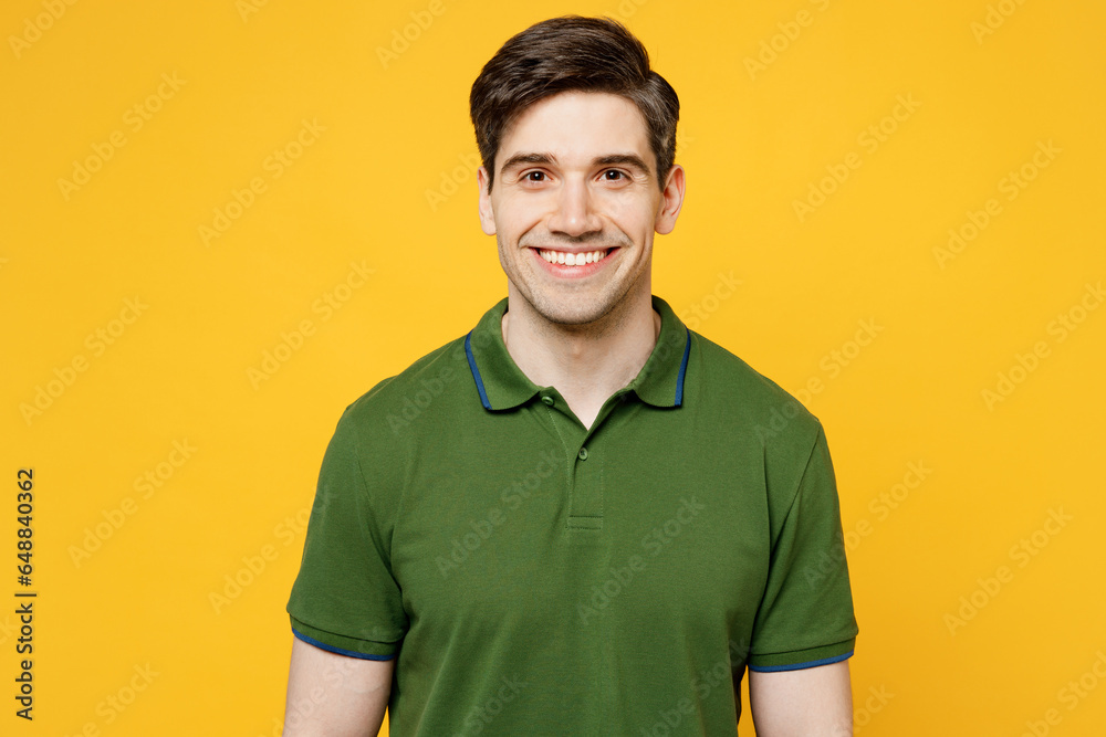 Young smiling cheerful satisfied positive cool fun happy caucasian man he wearing green t-shirt casual clothes look camera isolated on plain yellow wall background studio portrait. Lifestyle concept. Young smiling cheerful satisfied positive cool fun happy caucasian man he wearing green t-shirt casual clothes look camera isolated on plain yellow wall background studio portrait. Lifestyle concept.