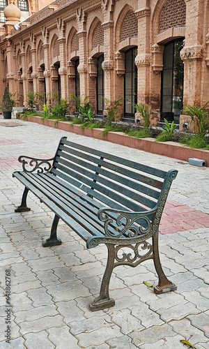 bench in the park with a vintage building in the background