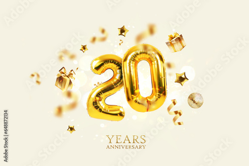 Fotografie Gold festive balloons 20 years anniversary with golden confetti, presents, mirror ball and stars fly on a beige background with bokeh lights and sparks