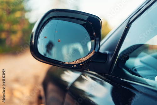Rear view mirror of SUV car with sands during off road 
