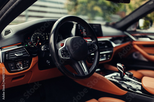 Modern supercar interior with leather panel, sport seats, multimedia and digital dashboard © Moose