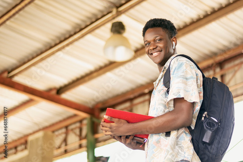 young black man with a backpack and a red folder