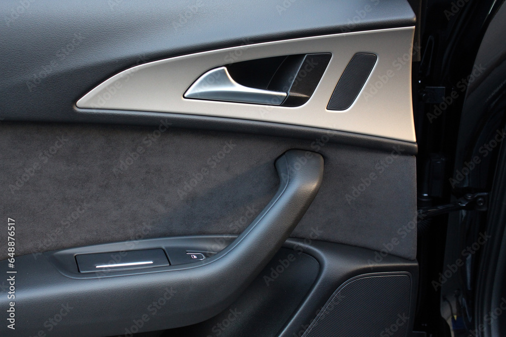 Rear passenger door trim. Car interior details. Modern car interior. Door handle with power window control.