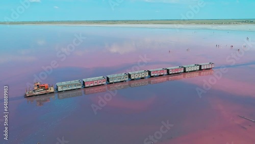 Aerial panorama of an old train standing on the railway in salt lake Bursol. Salt mining at pink lake in Altai region of Russia photo