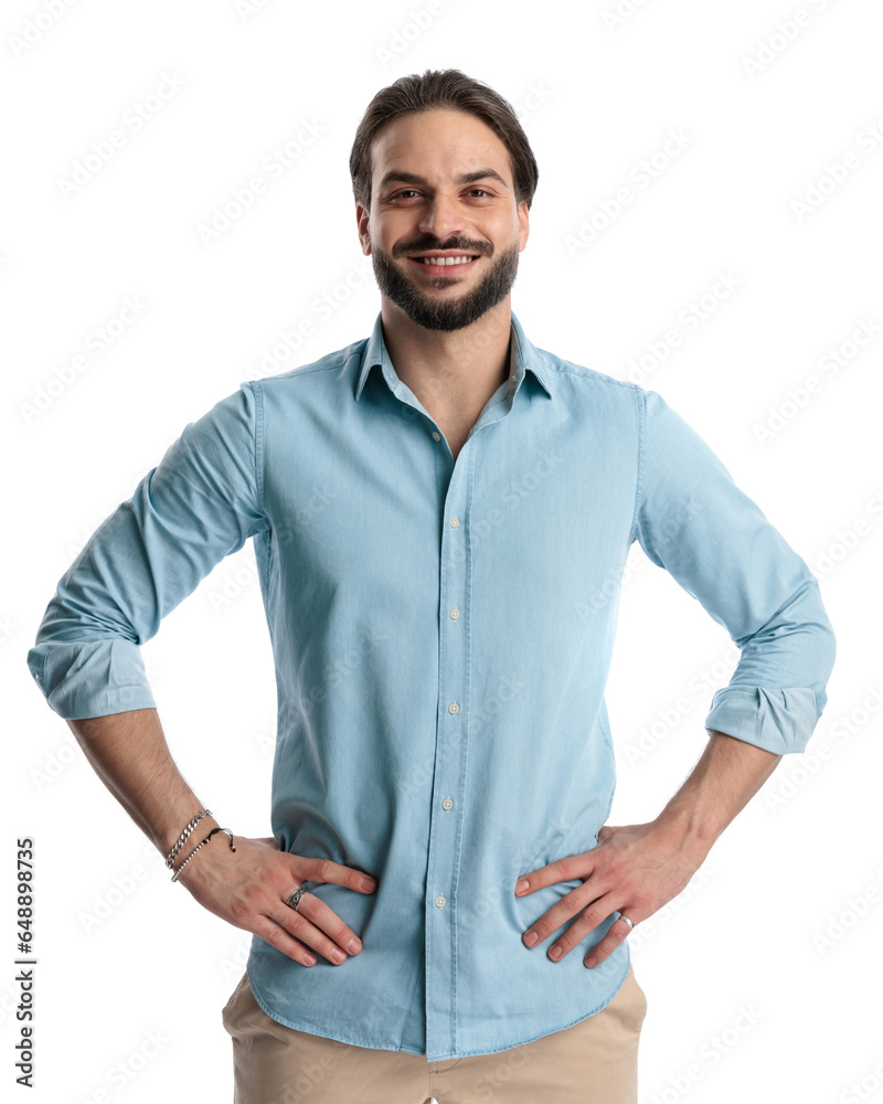 Fototapeta premium proud casual man in denim shirt holding hands on hips and smiling