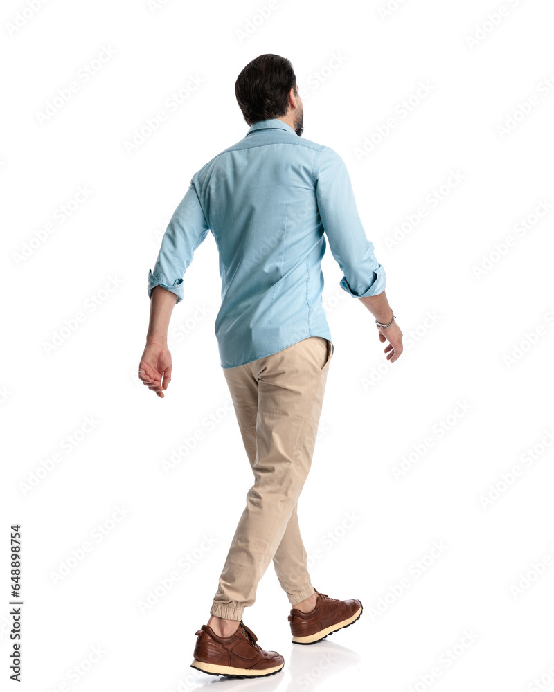 behind view of young man looking forward and stepping behind view of young man looking forward and stepping