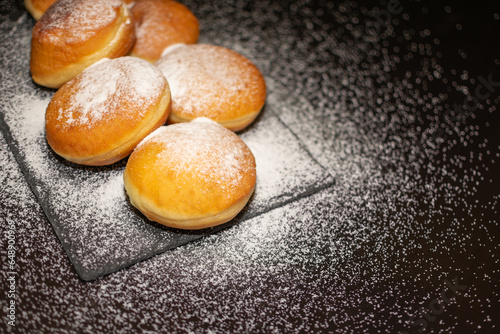 Canvas Print German Krapfen with drizzling glazed sprinkles in black elegant background
