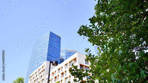 Modern apartment building and green trees. Ecological housing architecture. A modern residential building in the vicinity of trees. Ecology and green living in city, urban environment 