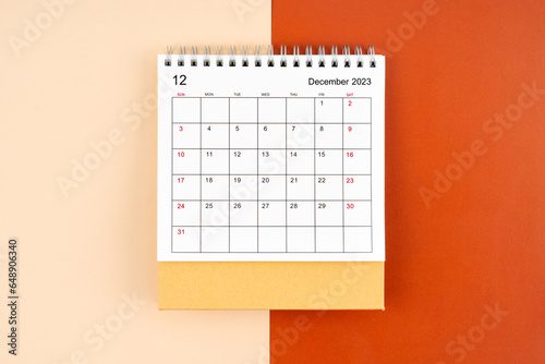 The Directly above view of December 2023 desk calendar on orange color background.
