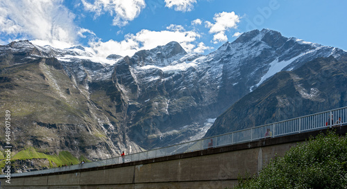 crest of the dam Drossensperre of the storage lake Mooserboden with the peaks of the mountains Bratschenkopf and Klockerin in the national park High Tauern of Salzburg, Austria photo