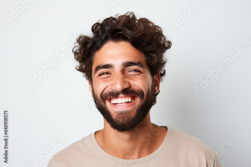 advertising portrait of smiling attractive young man with white teeth. Friendly expression. Spanish features. About 25 years old. Blurred background.