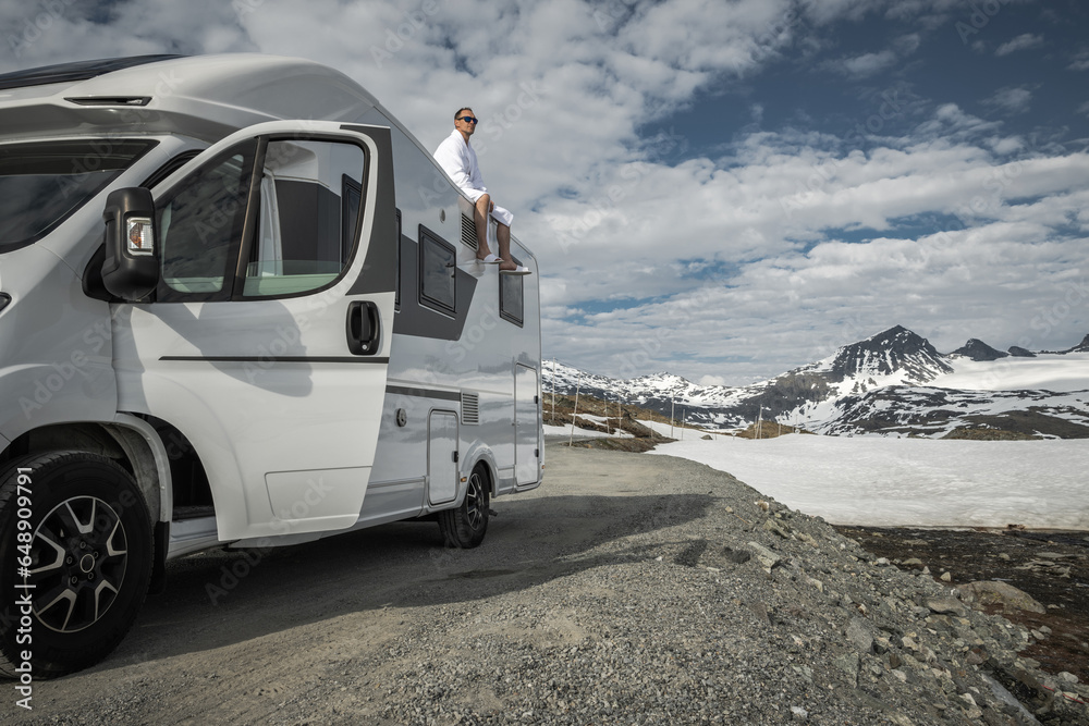 Tourist Enjoying Scenic Landscape While Seating on His Camper Van Roof