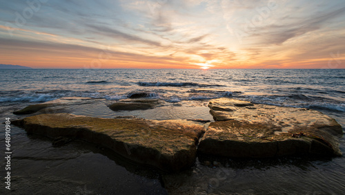 Waves on the rocks at the seaside at the sunset