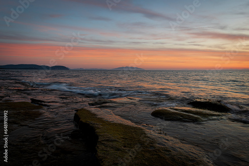 View of Elba island from Tuscany coast with flat rocks in the foreground © Fabiano