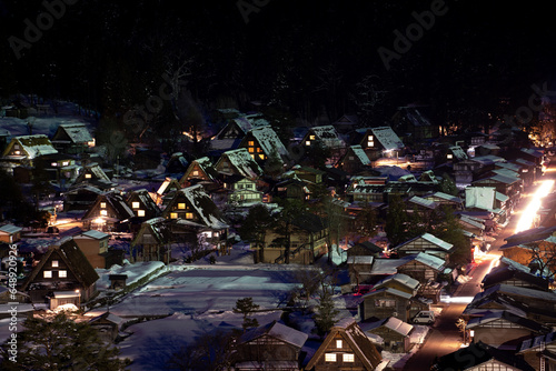 Under the veil of night, the winter-enshrouded Shirakawa village illuminates with the soft glow of lighted houses. photo