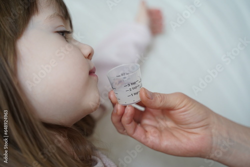 enfant malade boit du sirop photo