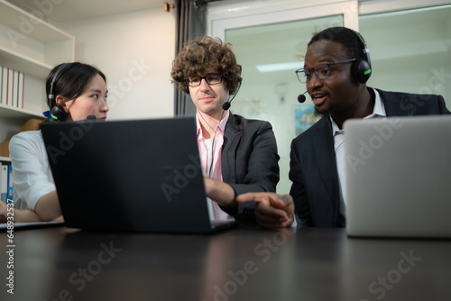 Group of business people wearing headset working actively in office. Call center, telemarketing, customer support agent provide service on telephone video conference call.