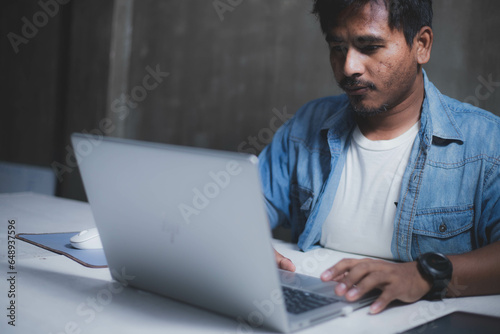 A business man is checking daily online stock market prices through a laptop at home with graphs displayed on the screen. Concept of daily business uncle
