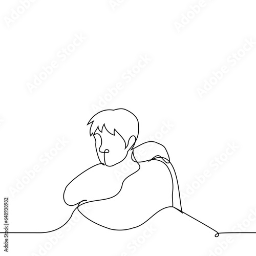 man sits hugging himself - one line art vector. concept melancholy, sadness