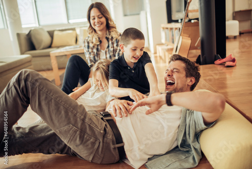 Fotografi Young Caucasian family playing in the living room at home