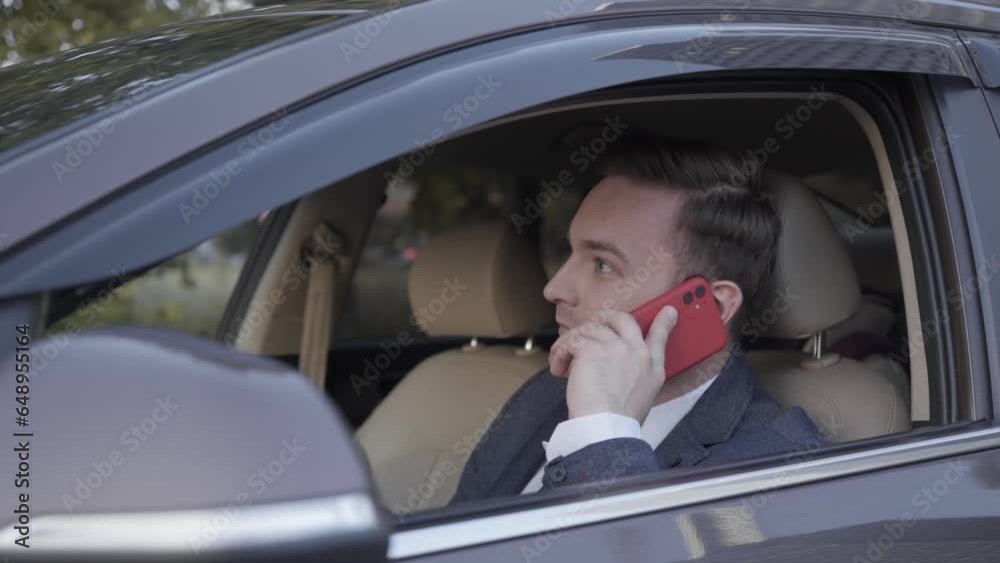A businessman in a suit sitting in a business car with white leather seats and talking on the phone A businessman in a suit sitting in a business car with white leather seats and talking on the phone