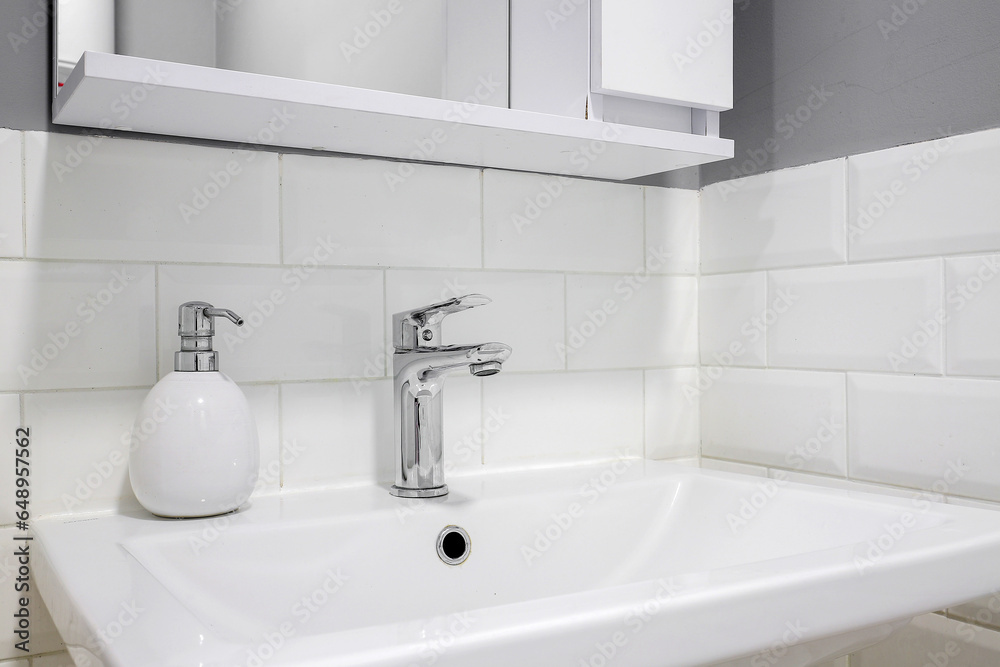 Chrome faucet with white ceramic sink in the bathroom Chrome faucet with white ceramic sink in the bathroom