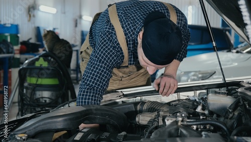 An auto mechanic inspects a car for damage. A mechanic diagnoses a car engine. Old car repair