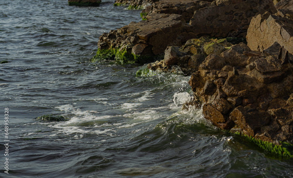 Background of sea waves crashing coast stones.