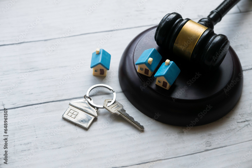 Concept of real estate auction, legal system and property division after divorce. Gavel and house key on a wooden background. - obrazy, fototapety, plakaty 