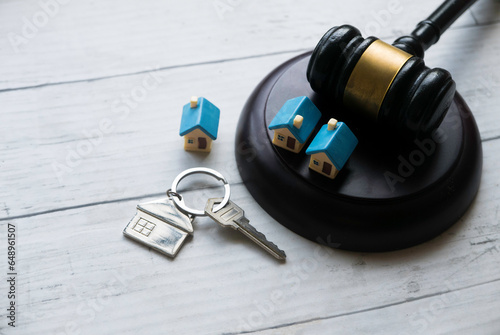 Concept of real estate auction, legal system and property division after divorce. Gavel and house key on a wooden background. photo