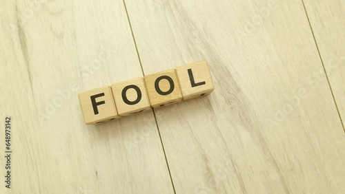 Fool word from wooden blocks. April Fools Day concept