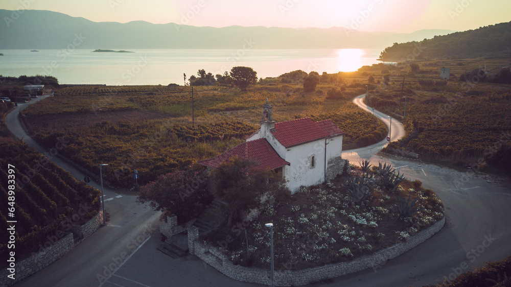 Fototapeta premium Drone photo of St. Cross church in the small town of Lumbarda on Korcula island, photographed during first dawn light