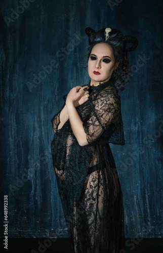 Beautiful woman witch with horns wearing black lacy dress
