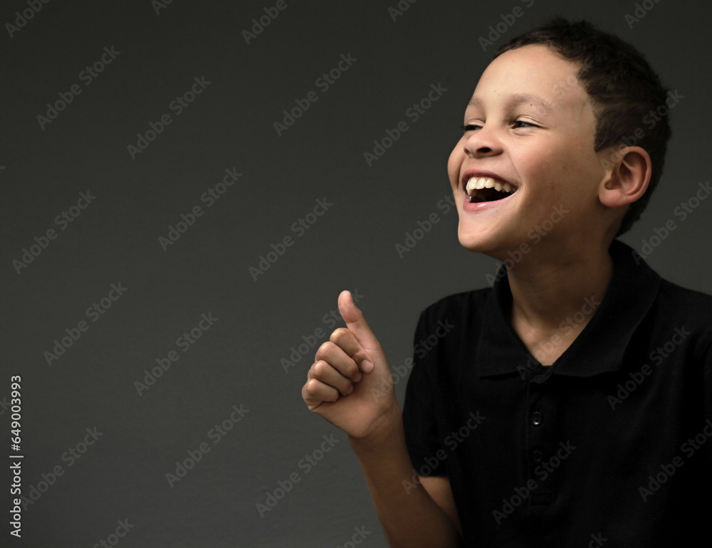 boy with thumbs up gesture on grey background with people stock photo boy with thumbs up gesture on grey background with people stock photo