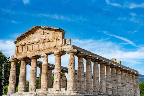 Ancient greek temples located in Italy in Peastum, Salerno with columns and blue sky and sun background