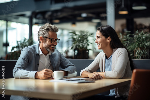 man and woman sitting at a table smiling on a date in a coffee shop