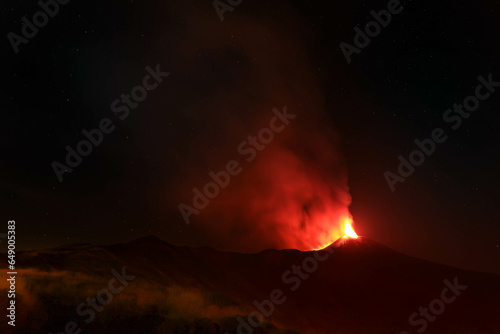 Panoramica sull'Etna durante una grande eruzione di notte con grande emissione di fumo e lava incandescente - Sicilia