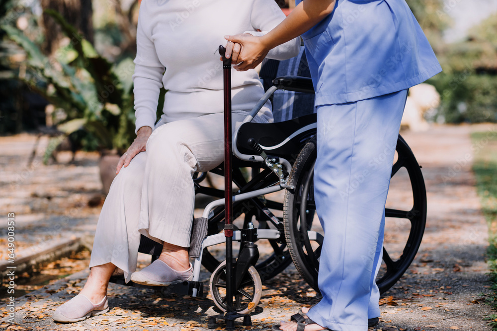 Obraz premium Asian young woman nurse at nursing home take care disabled senior man. Caregiver doctor serve physical therapy for older elderly patient to exercise and practice walking on walker or cane at backyard.