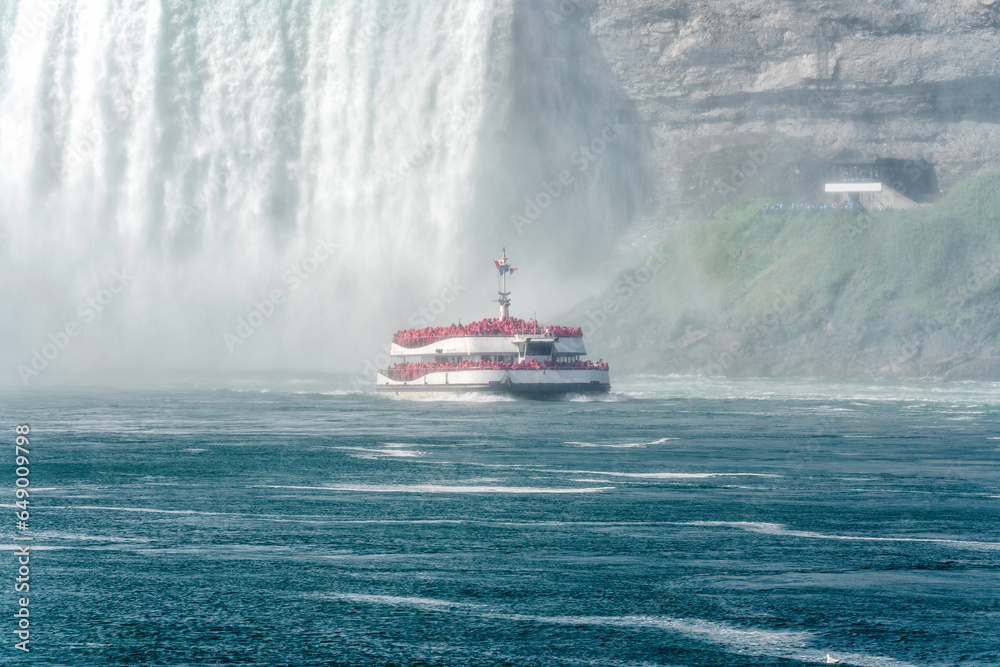 Fototapeta premium Tour boat sailing towards huge water flows down the waterfall, Horseshoe Water Fall in Niagara
