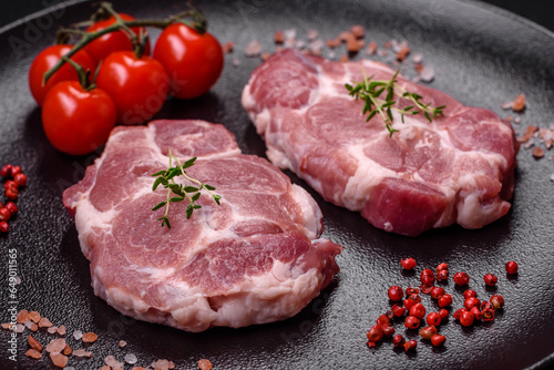 Fresh juicy pork steaks with salt, spices and herbs