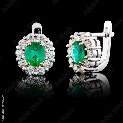 beautiful white gold earrings with diamonds and emeralds on a black background