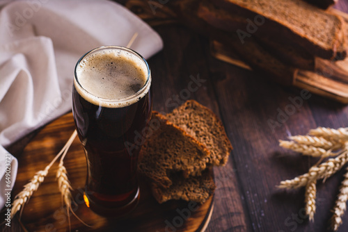 A glass of cold kvass and rye bread for fermentation on the table photo