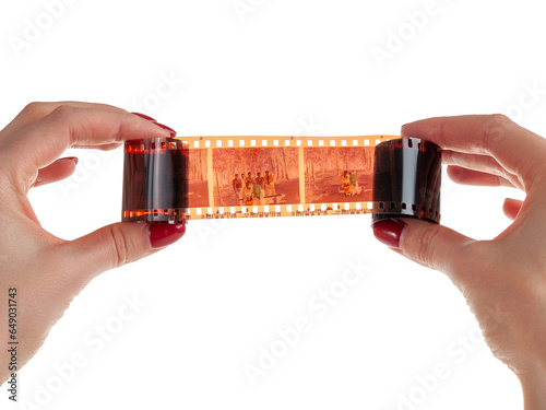 Exposed developed photo film negative in hands on white background, isolated analog photography, photo chemistry