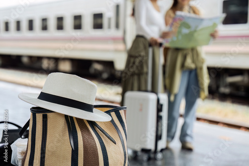 Hat and Bag at railway with passenger on background. travel concept