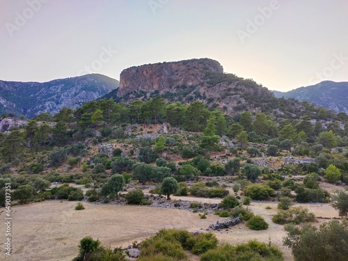 Pinara ruins of an ancient city near Fethiye, Mugla, Türkiye. Lycian tombs, ancient Roman amphitheater and mountains. photo