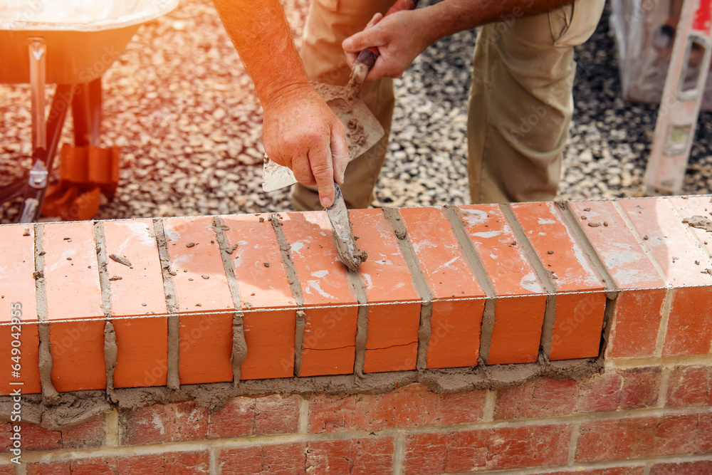 Close up of a brick wall and jointer trowel used by the worker to apply