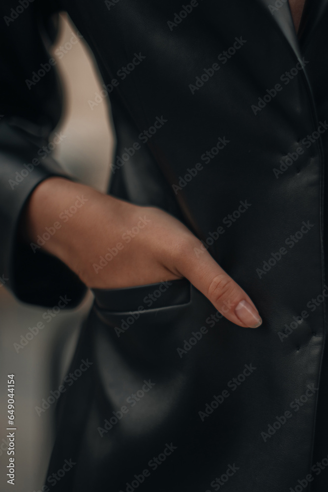Female hand in the pocket. Fashion details of a black leather jacket. Fancy outfit, vertical shot