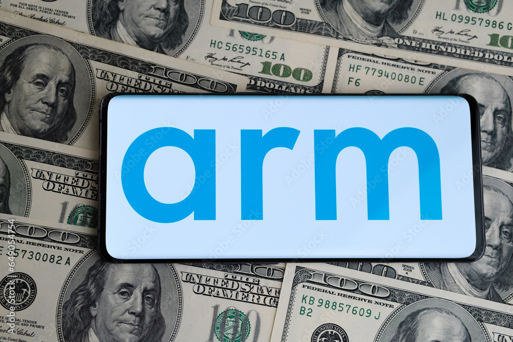 ARM logo seen on smartphone which is placed on hundred dollar bills