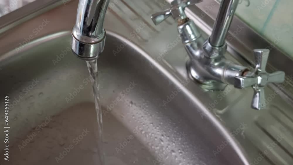Water flows in a thin stream from the tap. Water flows in a thin stream from the tap.