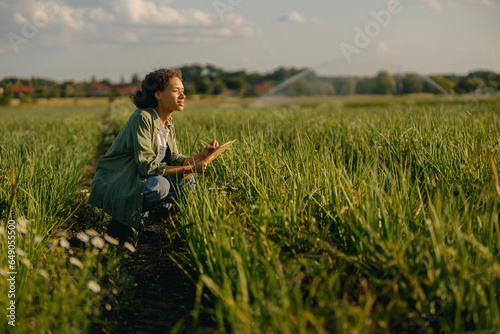 Female agronomist making notes in clipboard on field during harvesting. Agricultural concept